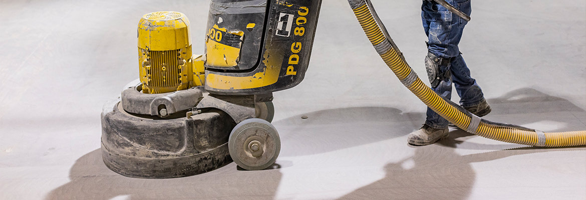 BNE concrete worker using concrete polishing machine to finish an interior concrete floor